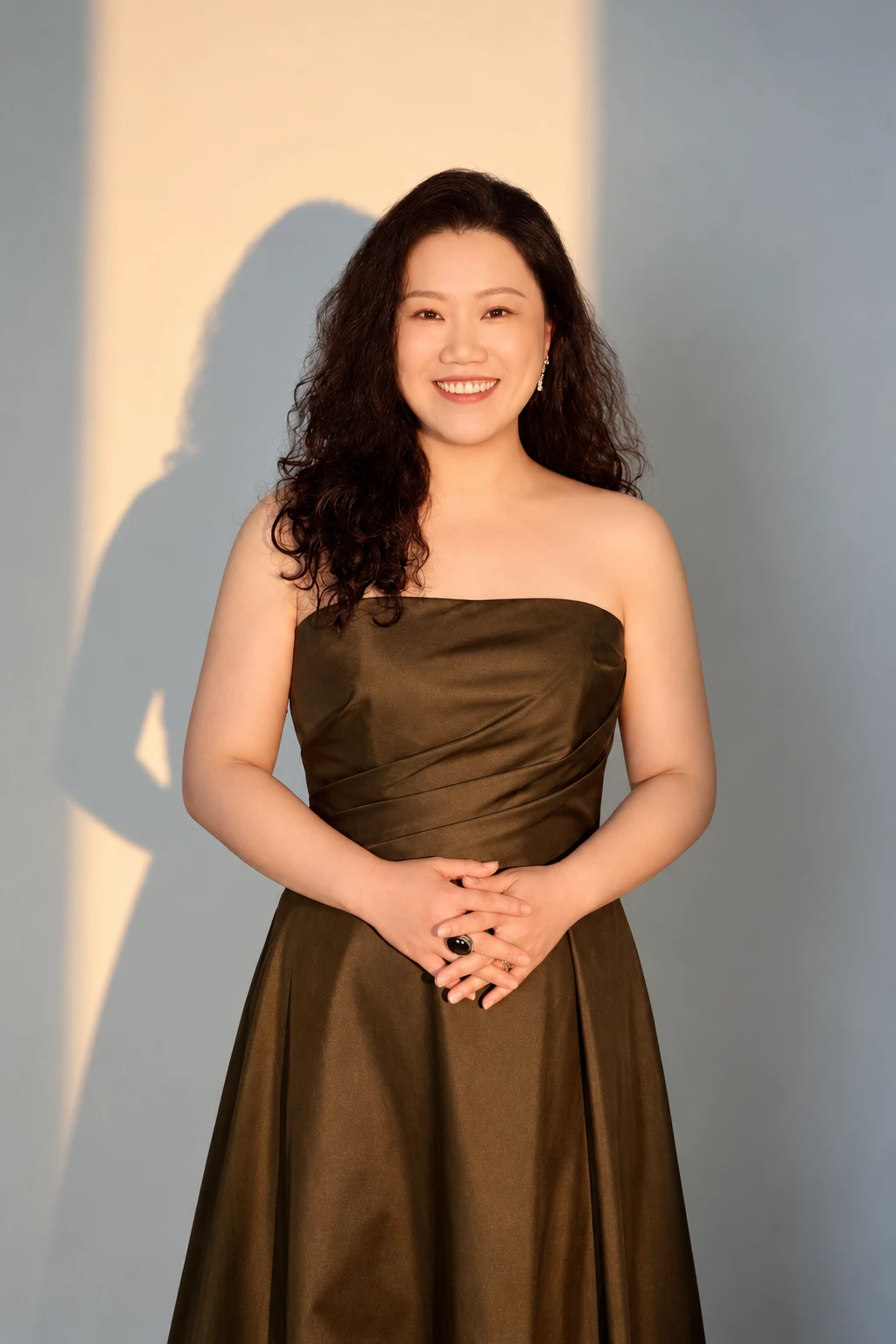 Ang Mei Foong in an olive-gold evening gown, artistic portrait, 2026
