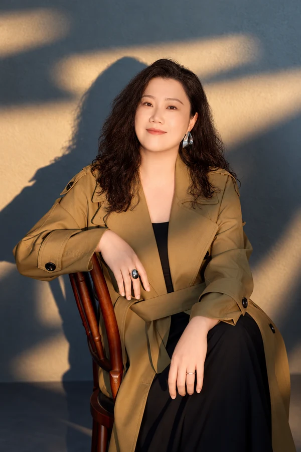Ang Mei Foong seated in an olive coat